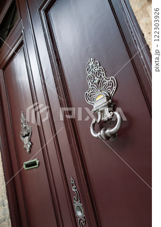 Elegant door knocker on a facade 122303926