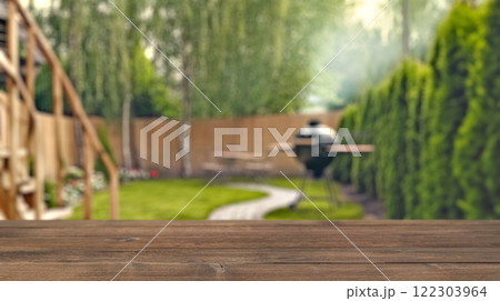 summer time party in backyard garden with grill BBQ, wooden table, blurred background summer time party in backyard garden with grill BBQ, wooden table, blurred background 122303964