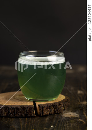 a green carbonated drink made with herbs with white foam 122304437
