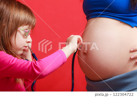 Daughter using stethoscope on pregnant mother Daughter using stethoscope on pregnant mother 122304722