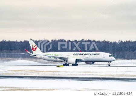 冬の新千歳空港　雪煙と離陸する飛行機　北海道千歳市　 122305434