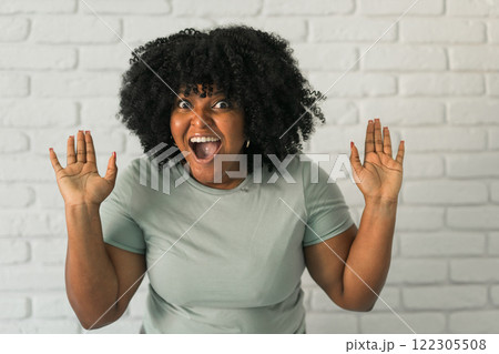 African American woman expressing pure joy with an enthusiastic and open expression. Excitement, energy and contagious sense of positivity African American woman expressing pure joy with an enthusiastic and open expression. Excitement, energy and contagious sense of positivity 122305508