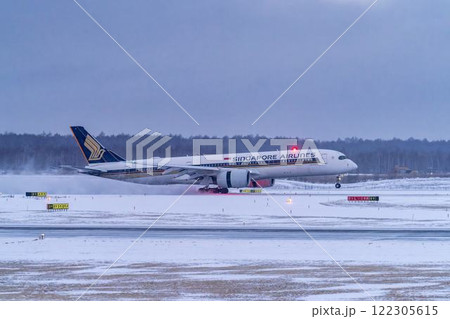 冬の新千歳空港　雪煙と着陸する飛行機　北海道千歳市　 122305615