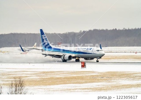 冬の新千歳空港 雪煙と着陸する飛行機 北海道千歳市 冬の新千歳空港 雪煙と着陸する飛行機 北海道千歳市 122305617