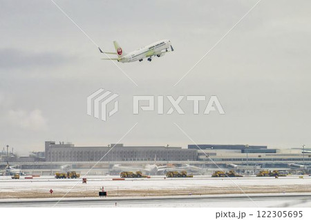 冬の新千歳空港　雪煙と離陸する飛行機　北海道千歳市　 122305695