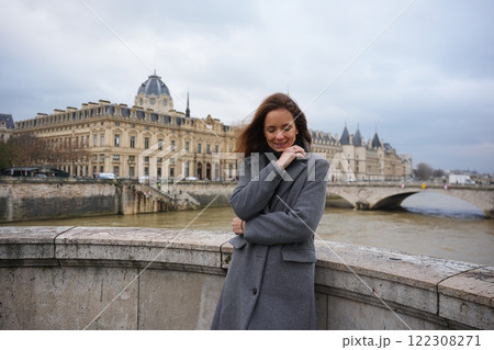 Woman Admiring Seine River and Paris Architecture on a Cloudy Day  122308271