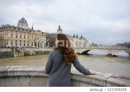 Woman Admiring Seine River and Paris Architecture on a Cloudy Day  122308280