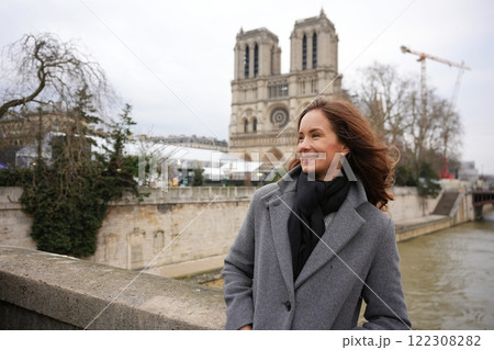 Smiling Woman Near Notre-Dame Cathedral, Paris, on a Breezy Winter Day 122308282