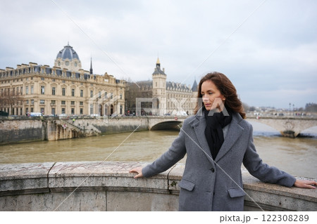 Woman Admiring Seine River and Paris Architecture on a Cloudy Day  122308289