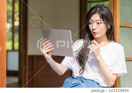 タブレット見て驚く若い女性 122310854