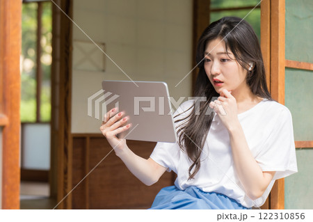 タブレット見て驚く若い女性 タブレット見て驚く若い女性 122310856