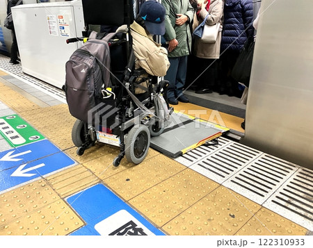 スロープを使って電車に乗る車椅子利用者 122310933