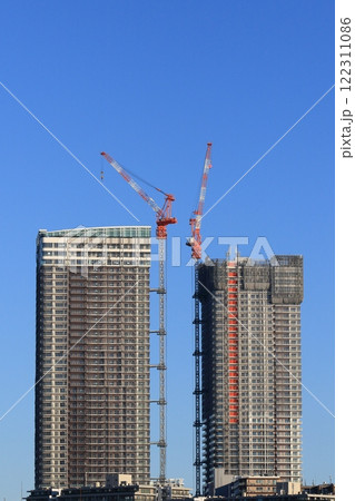 高層マンションの建築現場 建築中の高層ビルに設置されたタワークレーン 高層マンションの建築現場 建築中の高層ビルに設置されたタワークレーン 122311086