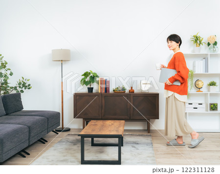 リビングルームを歩くミドル女性 122311128