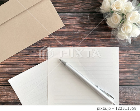 木製テーブルの上のレターセットとペン 122311359