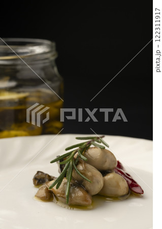皿に盛り付けた牡蠣のオイル漬け 122311917