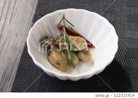 皿に盛り付けた牡蠣のオイル漬け 122311919