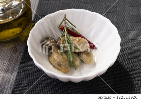 皿に盛り付けた牡蠣のオイル漬け 122311920