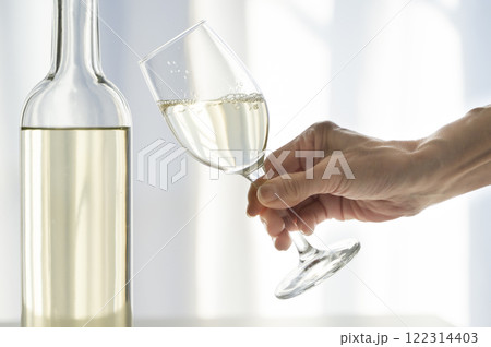 グラスに注がれた白ワインを持つ女性 グラスに注がれた白ワインを持つ女性 122314403