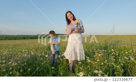 Happy Family Concept. Mom And Son Family Walking In Nature. Happy Family. Little Boys Hand Grips His Mothers Hand Tightly. Moves slowly. Happy Family Concept. Mom And Son Family Walking In Nature. Happy Family. Little Boys Hand Grips His Mothers Hand Tightly. Moves slowly. 122316677