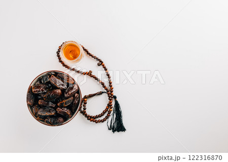 Muslim holiday decor, dates fruit, beads, and tea on a white background. 122316870