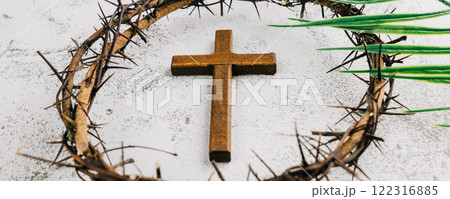 Palm Sunday setup with wooden cross, crown of thorns, and palm leaves on gray Palm Sunday setup with wooden cross, crown of thorns, and palm leaves on gray 122316885