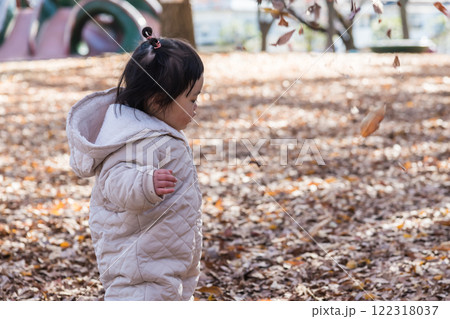 【落ち葉で敷き詰められた冬の公園で遊ぶ1歳児 立つ】 【落ち葉で敷き詰められた冬の公園で遊ぶ1歳児 立つ】 122318037