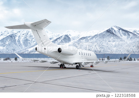 White luxury corporate aircraft at the airport apron on the background of high picturesque snow capped mountains 122318508