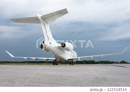 White luxury executive aircraft on the airport apron on a cloudy day White luxury executive aircraft on the airport apron on a cloudy day 122318514