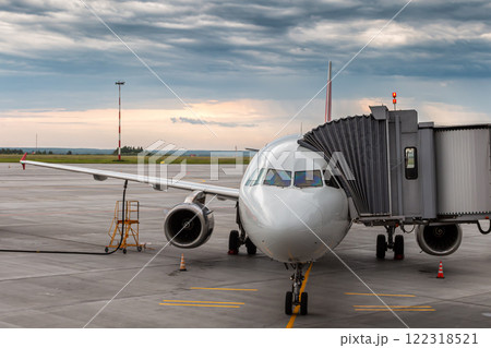 Modern passenger aircraft at the aerobridge in the evening Modern passenger aircraft at the aerobridge in the evening 122318521