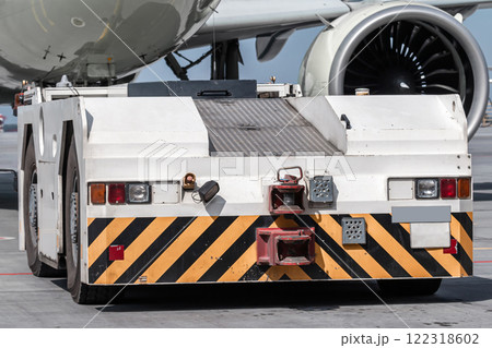 Close-up tow tractor pushes the passenger jetliner Close-up tow tractor pushes the passenger jetliner 122318602
