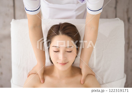 エステティシャンにマッサージを受ける女性 122319171