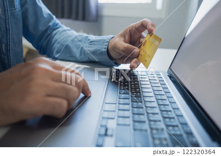 Man holding credit card while using laptop, shopping online, buying on internet. e-commerce e-banking service. Man holding credit card while using laptop, shopping online, buying on internet. e-commerce e-banking service. 122320364