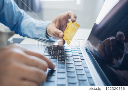 Man holding credit card while using laptop, shopping online, buying on internet. e-commerce e-banking service. 122320366