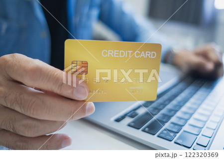 Close up, Man holding credit card while using laptop, shopping online, buying on internet. e-commerce e-banking service. 122320369