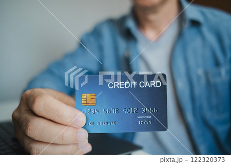 Close up, Man holding credit card while using laptop, shopping online, buying on internet. e-commerce e-banking service. Close up, Man holding credit card while using laptop, shopping online, buying on internet. e-commerce e-banking service. 122320373