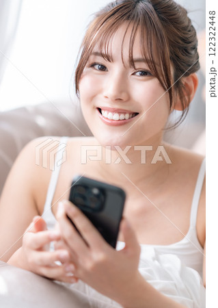 お部屋でスマホの画面を見る若い女性 お部屋でスマホの画面を見る若い女性 122322448