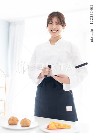 お菓子道具を持って微笑むパティシエ 122322463