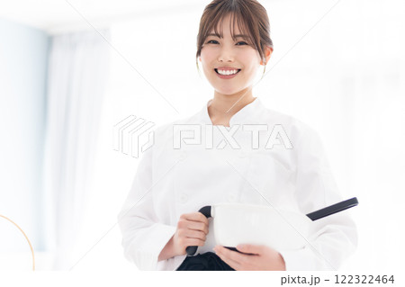 お菓子道具を持って微笑むパティシエ 122322464