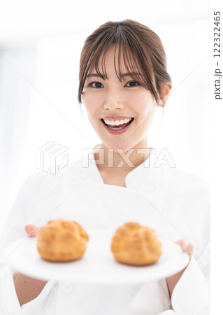 シュークリームを持って微笑むパティシエ 122322465