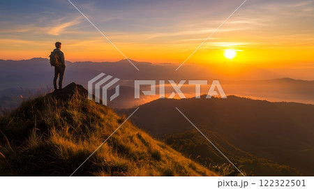 Hiker Watching a Glorious Sunrise from a Mountain Peak 122322501