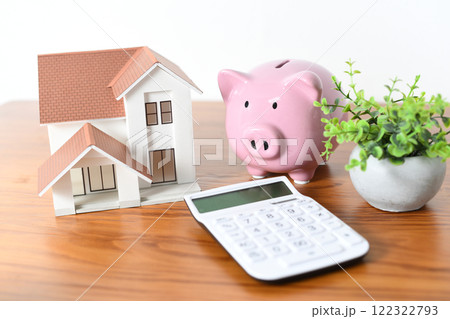 住宅模型と電卓と豚の貯金箱の金融イメージ 住宅模型と電卓と豚の貯金箱の金融イメージ 122322793