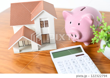 住宅模型と電卓と豚の貯金箱の金融イメージ 122322794