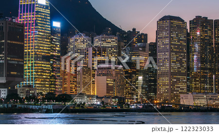 Hong Kong, China skyline panorama with skyscrapers day to night from across Victoria Harbor timelapse. 122323033