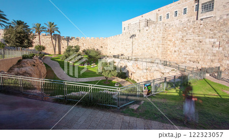 Defensive wall of the ancient holy Jerusalem timelapse hyperlapse, lit by the bright sun. Wonderful green lawn Defensive wall of the ancient holy Jerusalem timelapse hyperlapse, lit by the bright sun. Wonderful green lawn 122323057