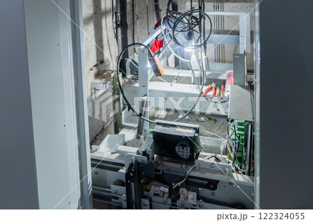 The elevator mechanisms are visible through the open doors, the equipment is being repaired after replacement, installation or breakdown, and maintenance. Advanced Robotics Machinery and Equipment in The elevator mechanisms are visible through the open doors, the equipment is being repaired after replacement, installation or breakdown, and maintenance. Advanced Robotics Machinery and Equipment in 122324055