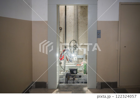 Elevator breakage, elevator doors open during machinery repairs. An interior view of an elevator machinery room that showcases various essential mechanical components 122324057