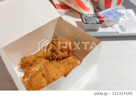 Fried chicken legs are a popular fast food restaurant dish. Unhealthy fried food, Enjoying a delicious takeout box filled with crispy fried chicken, a classic favorite delight Fried chicken legs are a popular fast food restaurant dish. Unhealthy fried food, Enjoying a delicious takeout box filled with crispy fried chicken, a classic favorite delight 122324105