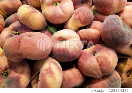 Stack of Flat peaches on a market stall Stack of Flat peaches on a market stall 122324323
