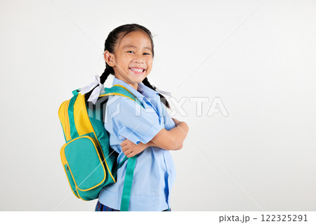 Portrait smiling Asian little girl kindergarten with schoolbag crossed arms studio shot isolated white background, good job feedback, happy woman kid in pigtails wearing school uniform, back to school 122325291